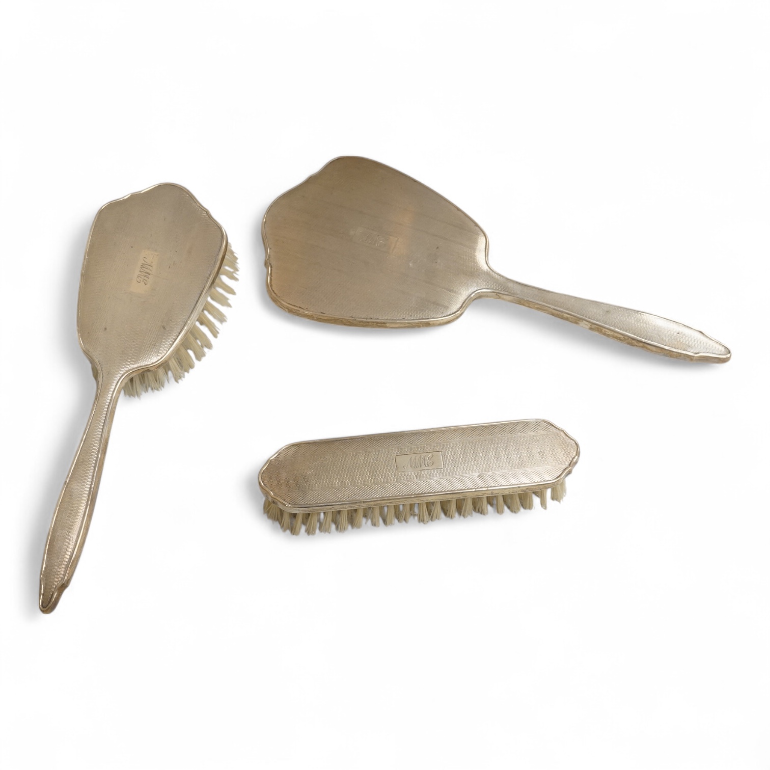 An early 1960's silver mounted hand mirror, 24.7cm and two matching brushes, Adie Bros. Birmingham, 1960.